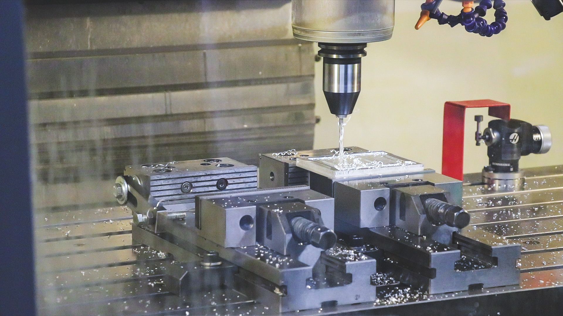 Metal milling, or CNC, machine drilling into a block of metal.