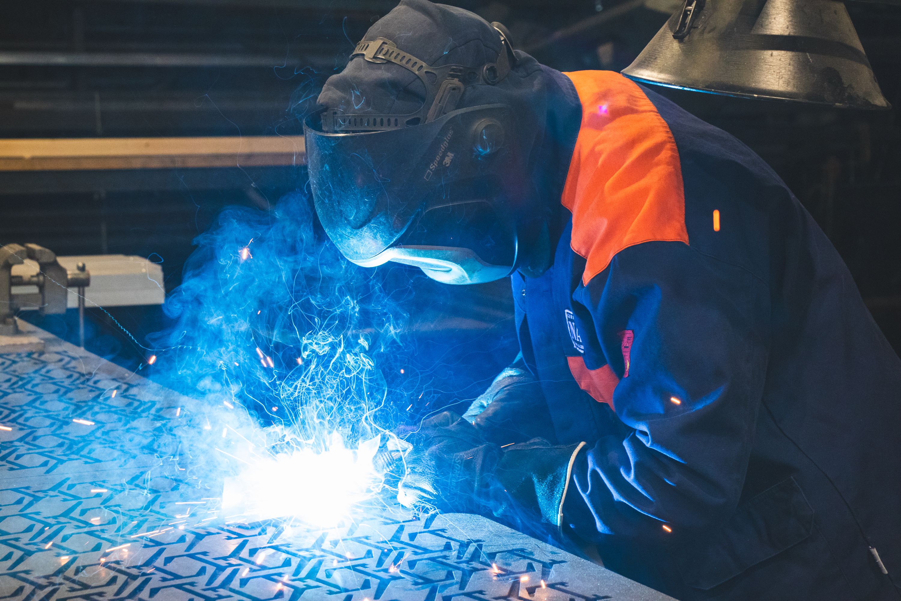 A person welding on a metal sheet