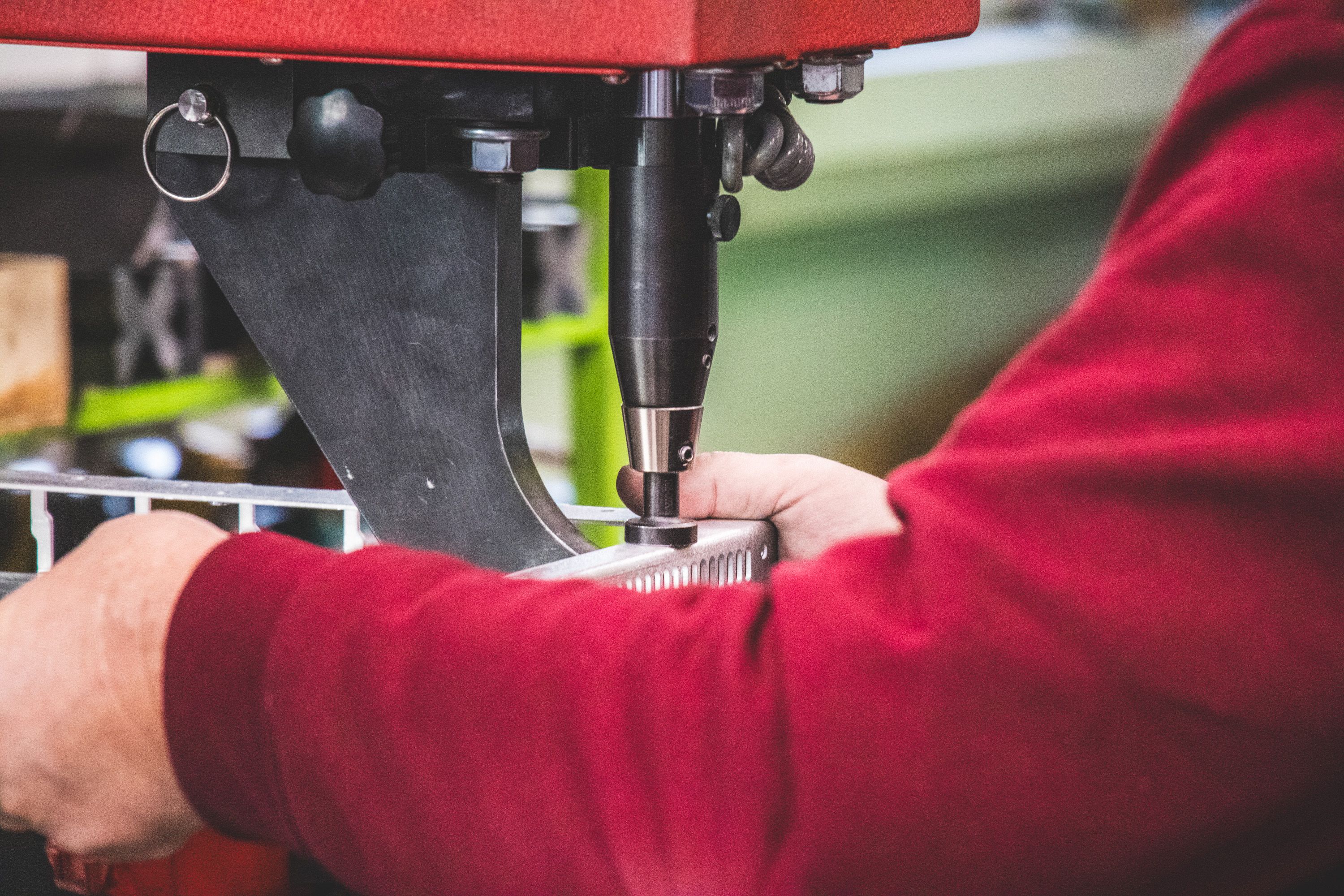 Close up of hands holding a metal frame under the insertion machine